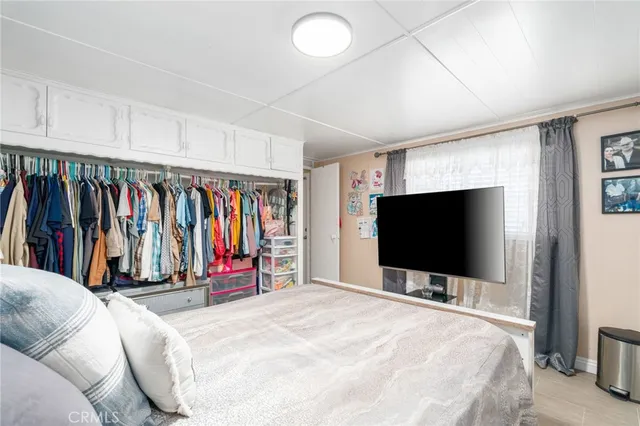 a bedroom with a bed and a flat screen tv