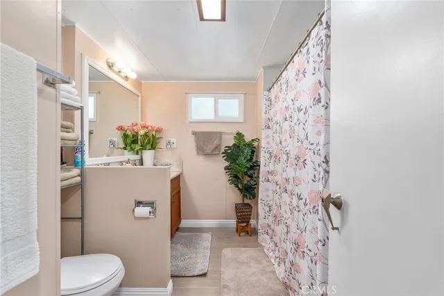 a bathroom with a toilet sink and shower curtain