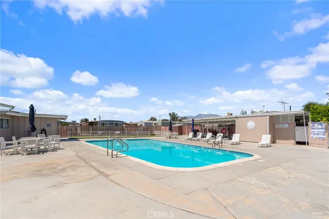 a swimming pool with outdoor seating and barbeque oven
