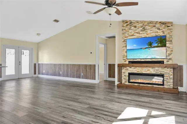 a view of an empty room with a fireplace and a window