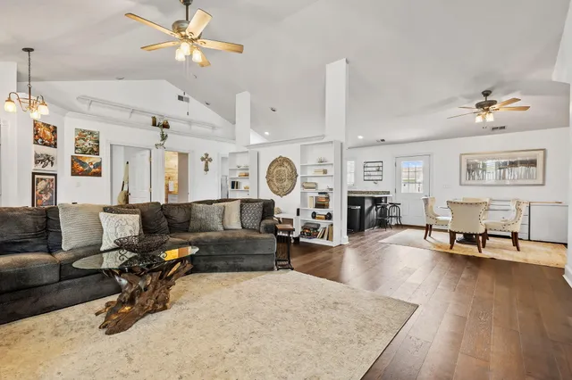 a living room with furniture a clock and a chandelier