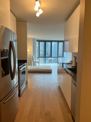 a kitchen with kitchen island a counter top space a sink stainless steel appliances and cabinets