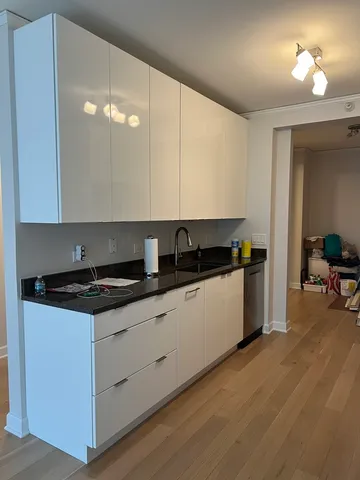 a kitchen with granite countertop a stove a sink a refrigerator and chairs