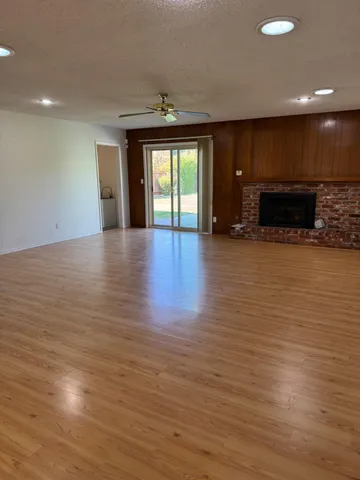 a view of empty room with wooden floor and fireplace