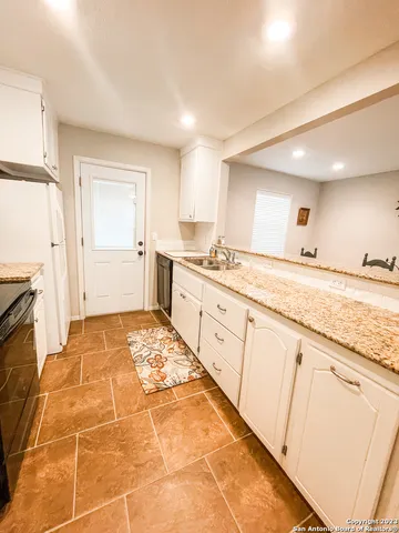 a spacious bathroom with a granite countertop sink a mirror and a shower