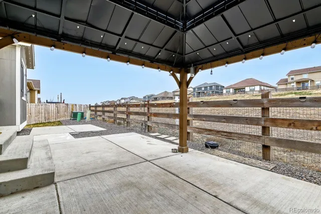 a view of a terrace with a table and chairs under an umbrella