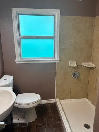 a white toilet sitting next to a bath tub