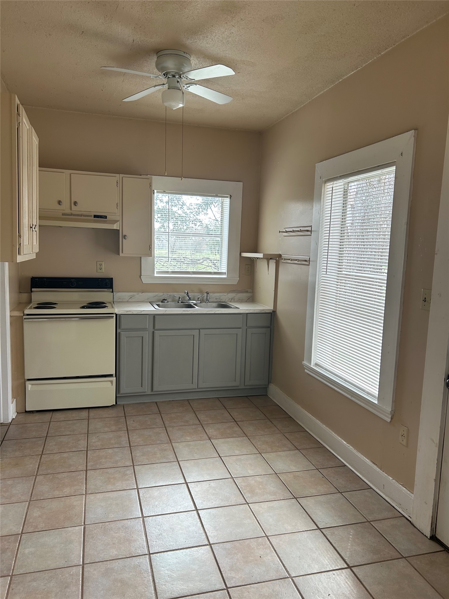 1609 Cedar Street Bastrop, TX 78602 - Photo 4 of 7 Kitchen with electric stove, light countertops, light tile patterned floors