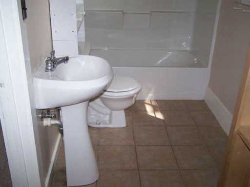 1609 Cedar Street Bastrop, TX 78602 - Photo 6 of 7 Full bathroom with tile patterned flooring and washtub / shower combination