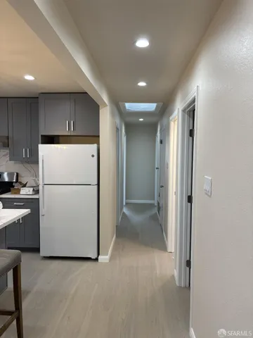 a view of a kitchen with a refrigerator a stove top oven and cabinets