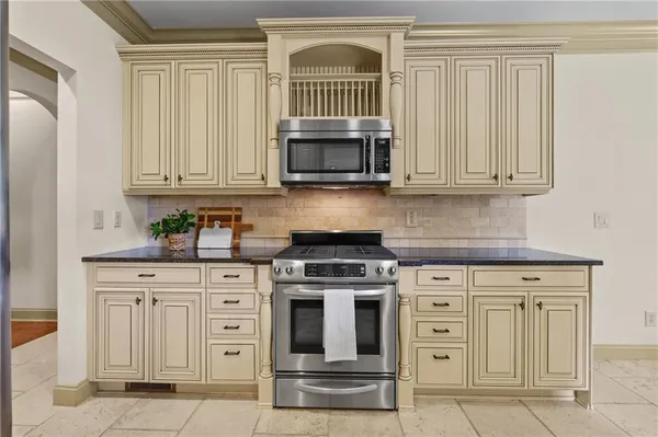 a kitchen with granite countertop white cabinets and stainless steel appliances