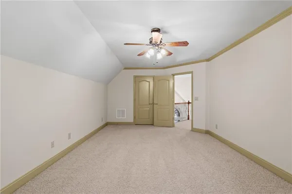 an empty room with chandelier fan and windows