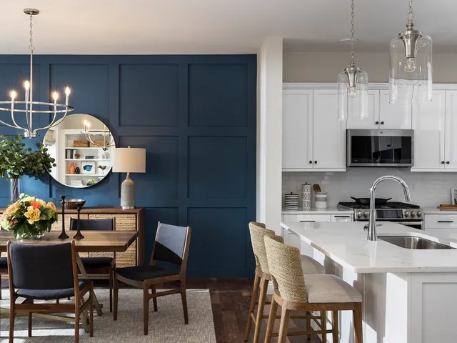 a kitchen with stainless steel appliances a dining table chairs and a microwave