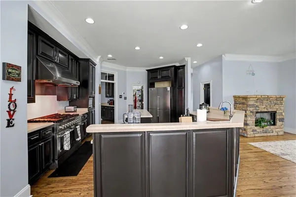 a large living room with furniture a fireplace and a kitchen