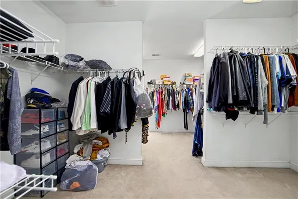 a view of walk in closet with clothes and shoes