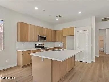 a kitchen with a sink a stove a refrigerator a center island and a window