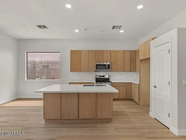 a large kitchen with stainless steel appliances granite countertop a sink a stove a refrigerator and cabinets