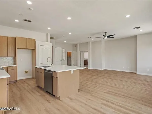 a large kitchen with stainless steel appliances a large counter top a sink and a refrigerator