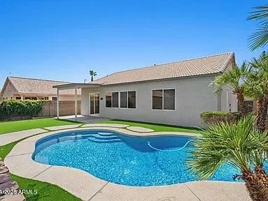 a view of a house with pool and a yard
