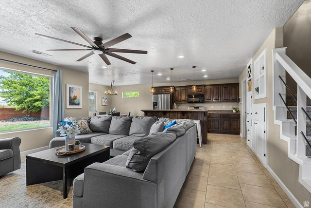 225 Falcon Court Ivins, UT 84738 - Photo 4 of 47 Living room with light tile patterned floors, healthy amount of natural light, ceiling fan, a textured ceiling, and hanging lights