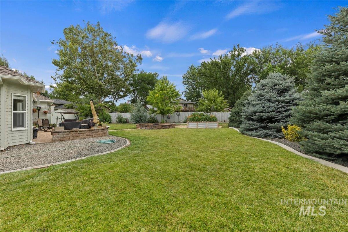 5184 North Greyloch Way Boise, ID 83704 - Photo 22 of 32 Expansive backyard featuring a manicured lawn and mature trees