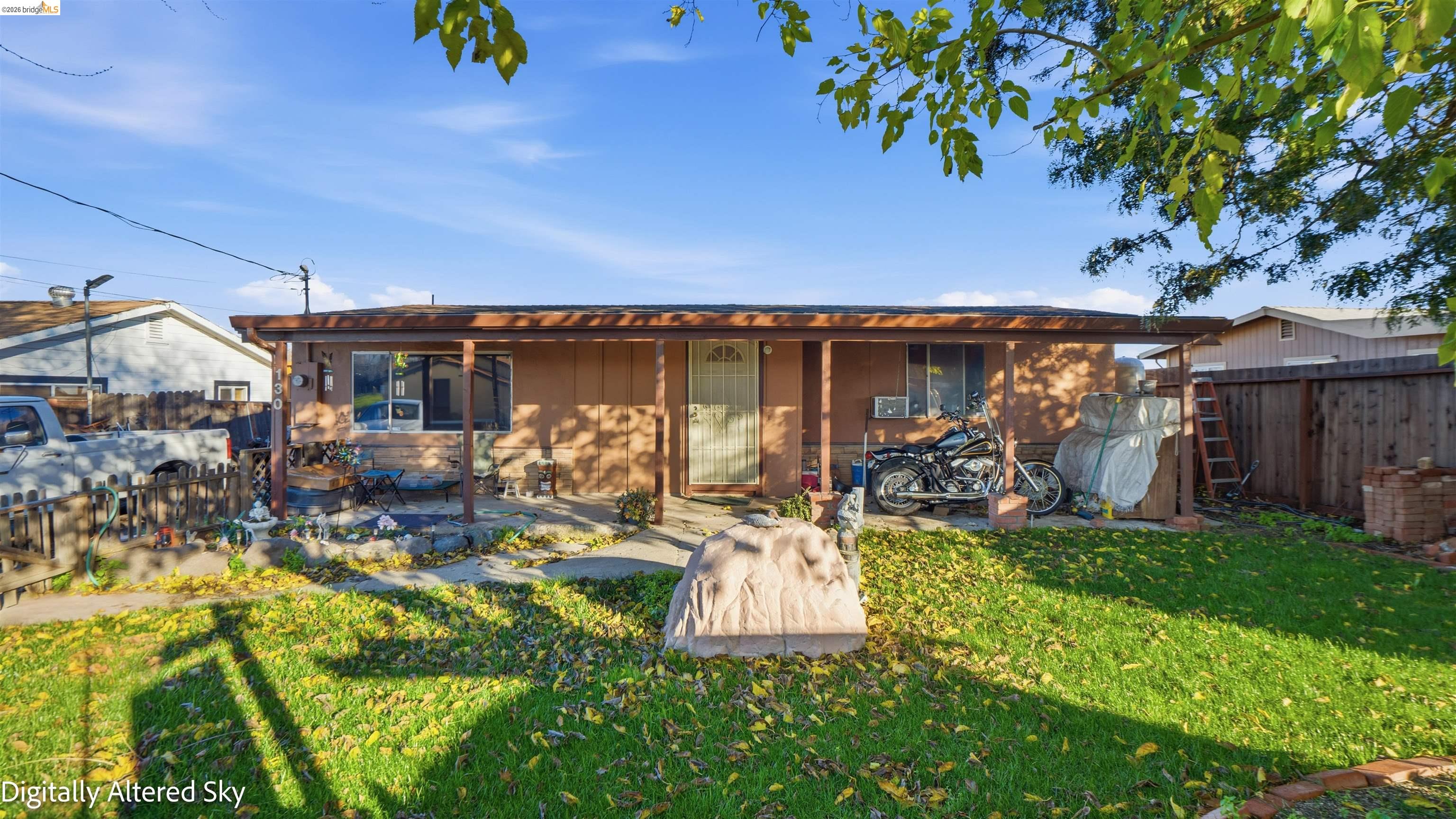 Rear view of house featuring a fenced backyard and a porch
