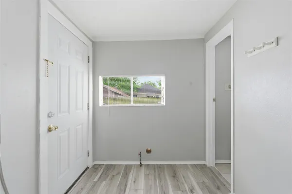a view of small space with wooden floor and a window