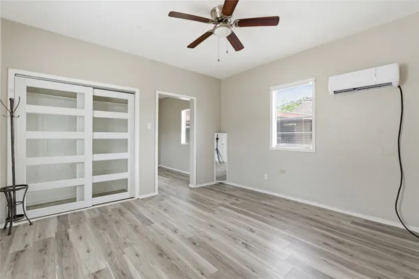 a view of an empty room with a window and wooden floor