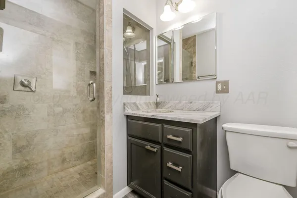 a bathroom with a granite countertop sink toilet and shower