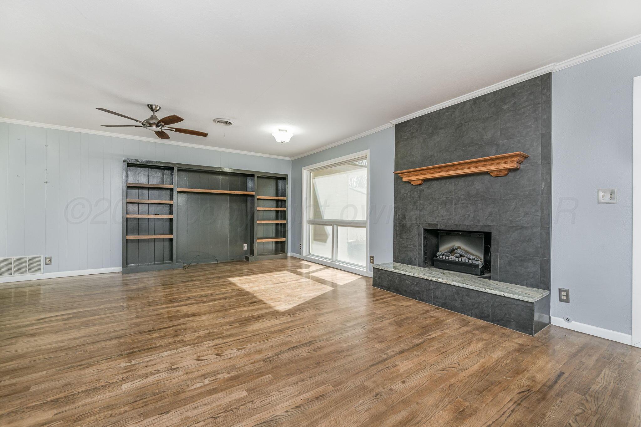 4305 Omaha Avenue Amarillo, TX 79106 - Photo 3 of 20 a view of an empty room with a fireplace and a window