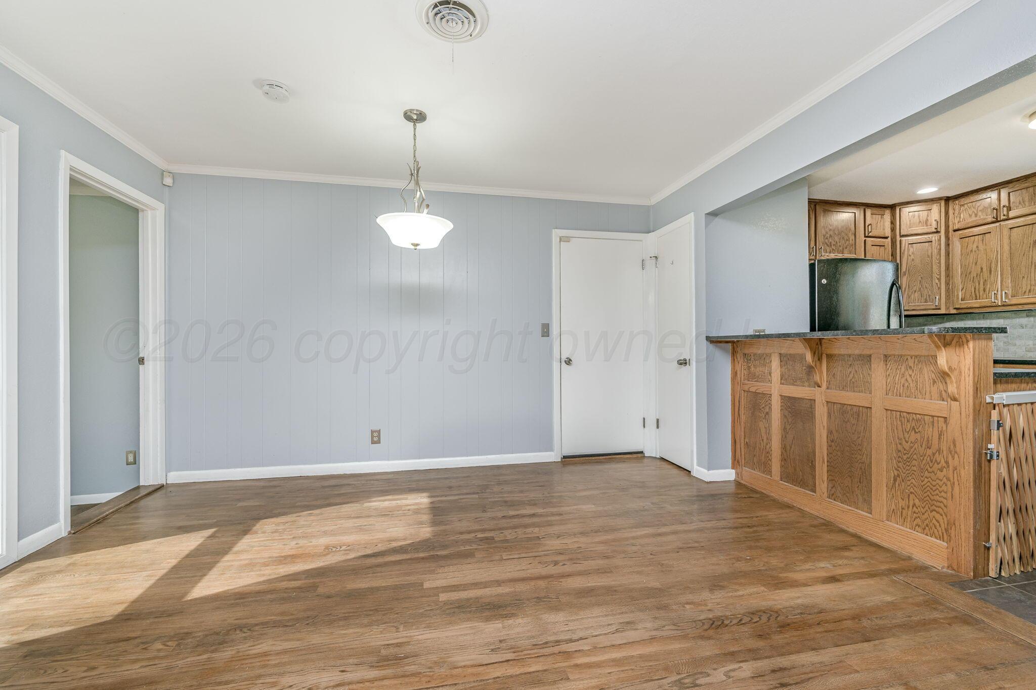 4305 Omaha Avenue Amarillo, TX 79106 - Photo 5 of 20 a view of an empty room with window and wooden floor