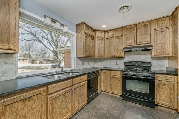 a kitchen with stainless steel appliances granite countertop a stove and a sink