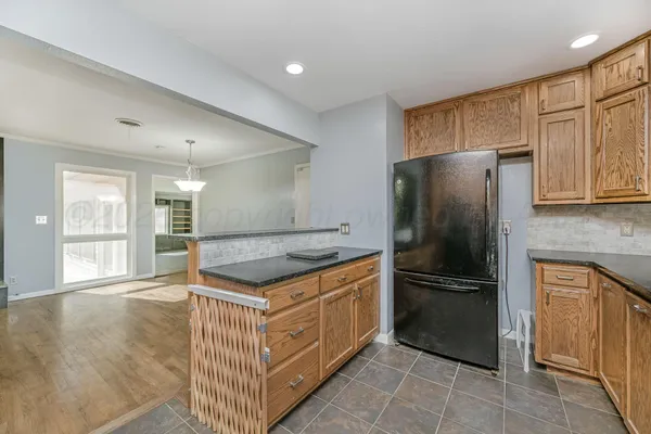 a kitchen with stainless steel appliances granite countertop a refrigerator and a stove