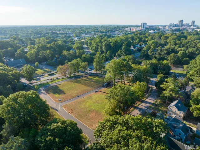 an aerial view of residential houses with outdoor space and trees