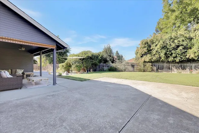 a view of a house with a backyard and a tree