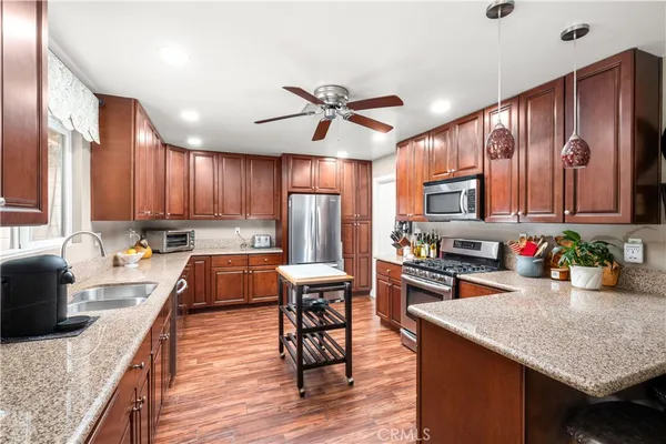 a kitchen with stainless steel appliances granite countertop a refrigerator stove microwave and cabinets