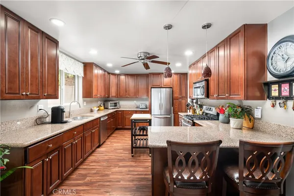 a kitchen with stainless steel appliances granite countertop a sink a stove and a refrigerator