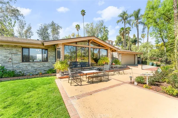 a view of a house with backyard and sitting area