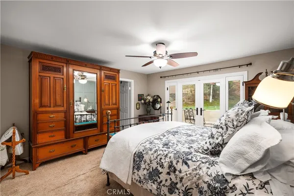 a spacious bedroom with a large bed and a chandelier
