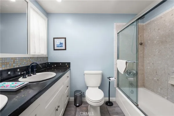 a bathroom with a granite countertop toilet sink and mirror