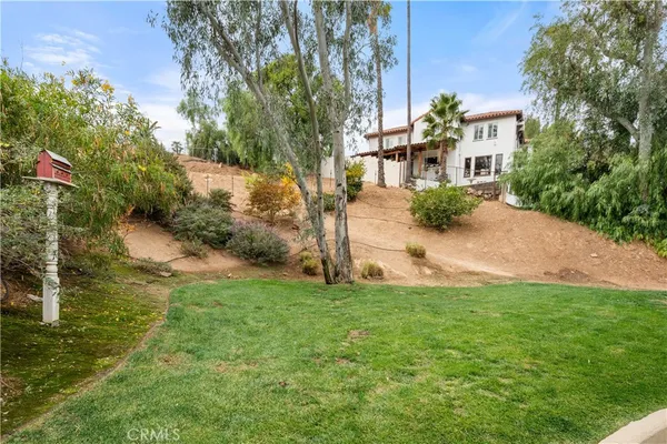 a front view of a house with a yard and potted plants