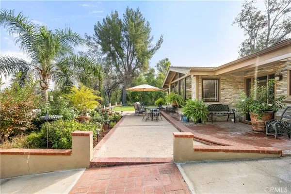 a front view of a house with a yard and potted plants