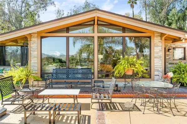 a patio with glass top table and chairs
