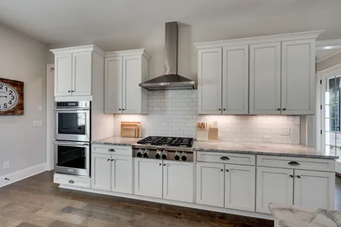 a kitchen with white cabinets and appliances