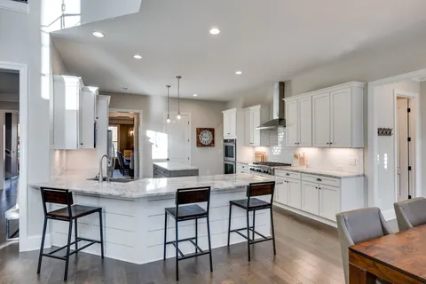 a kitchen with kitchen island granite countertop a sink and cabinets