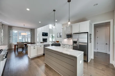 a large kitchen with white cabinets and stainless steel appliances