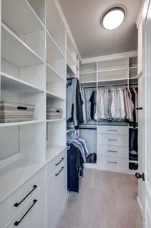 a view of walk in closet with clothes and shoes