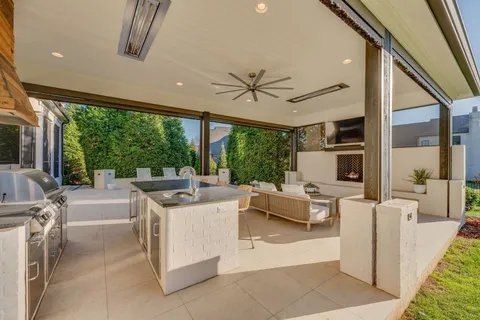 a living room with furniture a large window with kitchen view