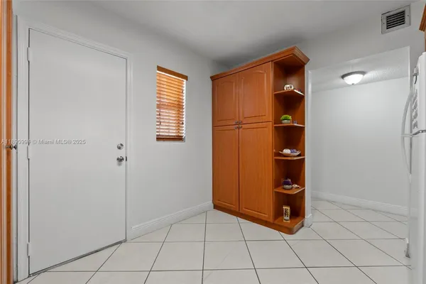 a view of an empty room and a kitchen