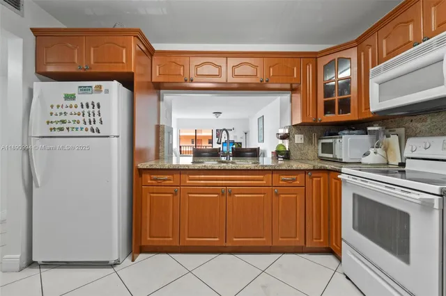 a kitchen with stainless steel appliances granite countertop a refrigerator and a stove